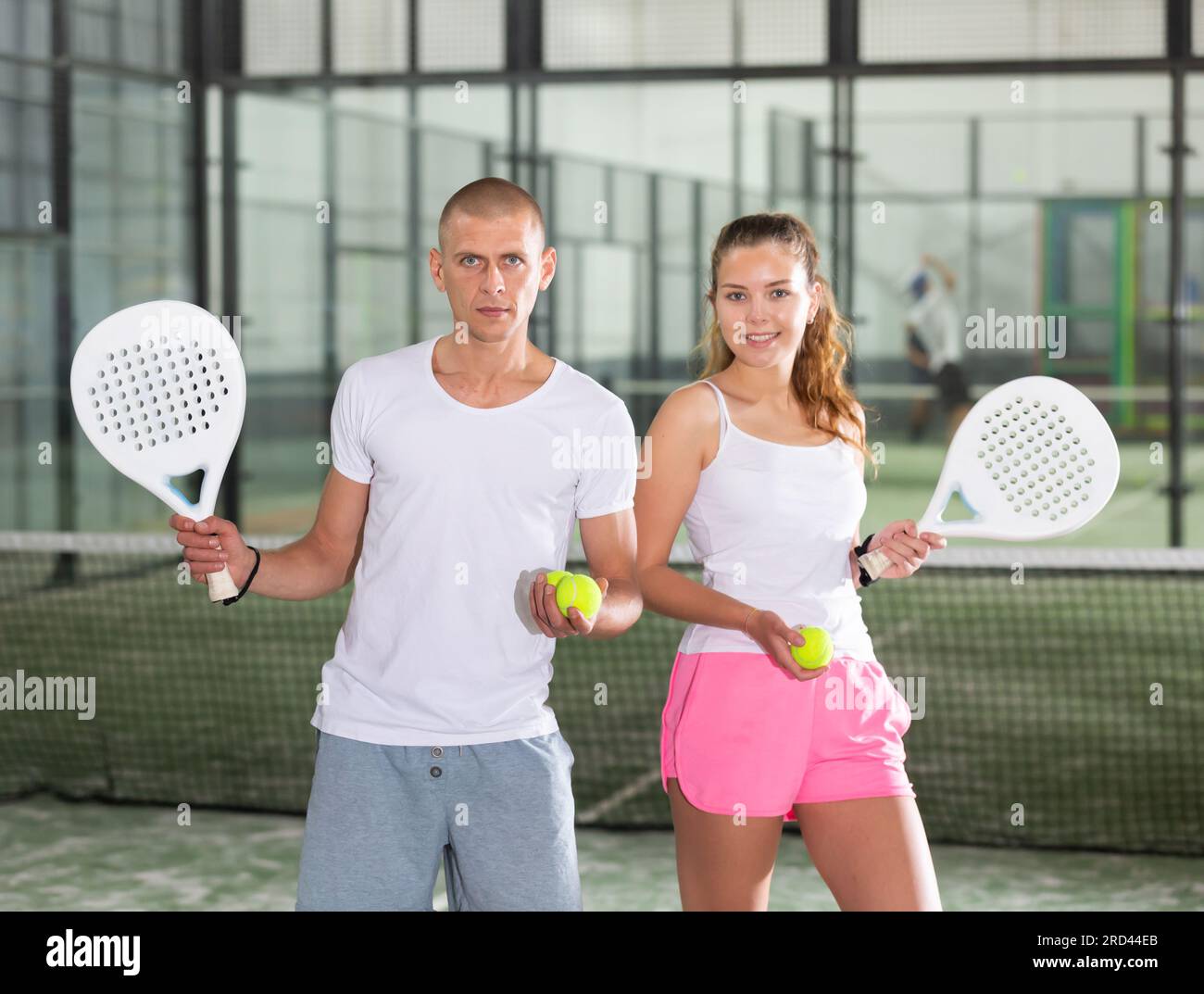 Couple with padel rackets posing on tennis court Stock Photo Alamy