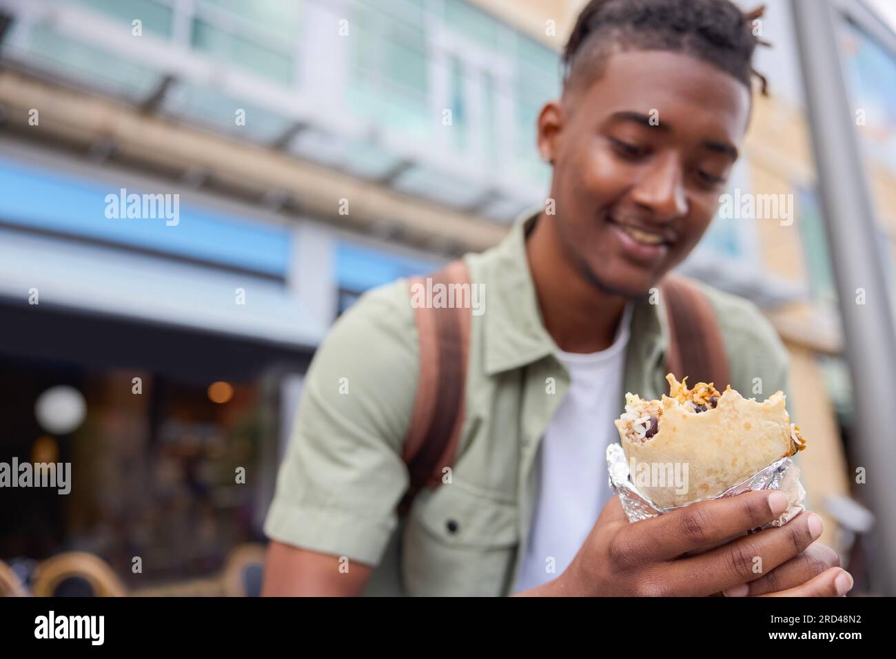 Young Man Eating Burrito At Outdoor Street Food Stall Stock Photo Alamy