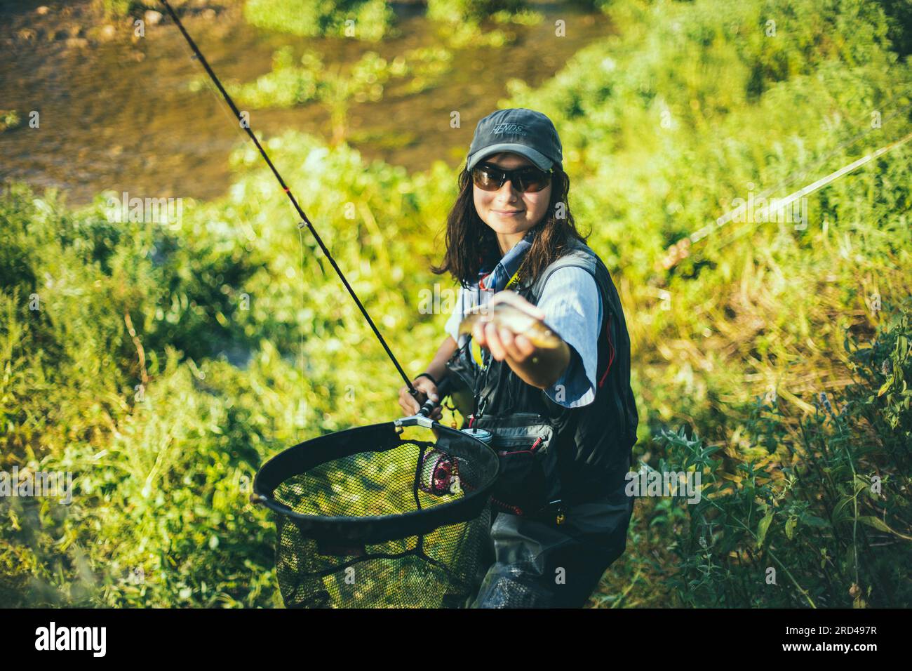 A woman enjoying the sport of fly fishing with her guide poling throught  the flats of Blanket Sound off Kamalama Cay, Andros Stock Photo - Alamy