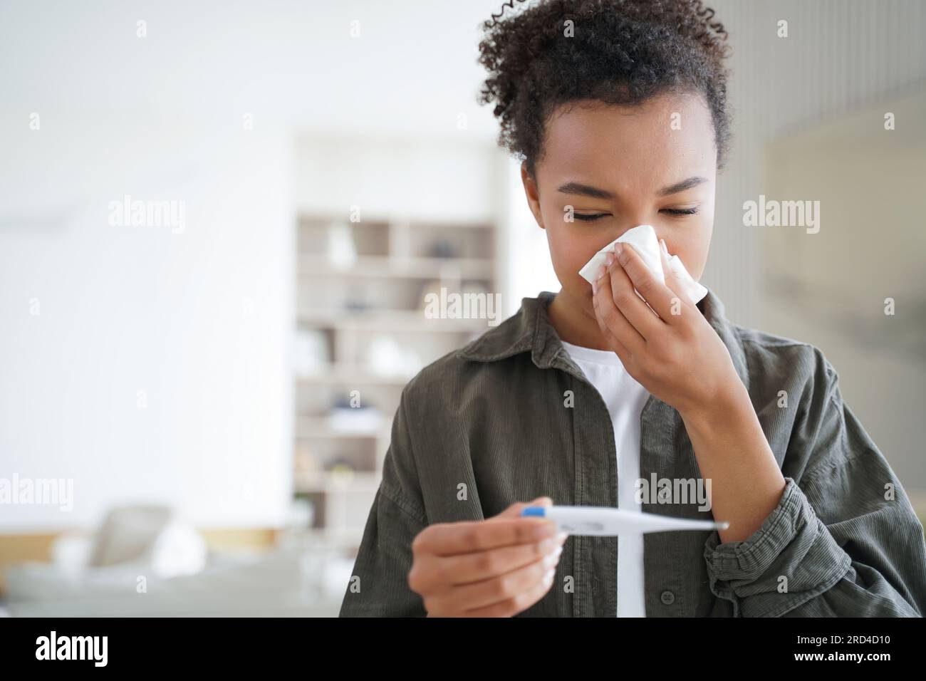 Sick mixed race teen girl blows nose, measures temp with electronic