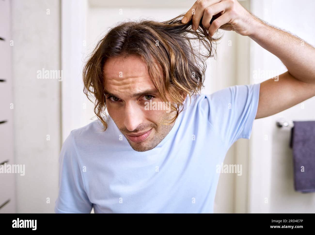 Healthcare, man checking his hair and grooming in bathroom of his home. Mental health or stress, body care or health wellness treatment and male Stock Photo