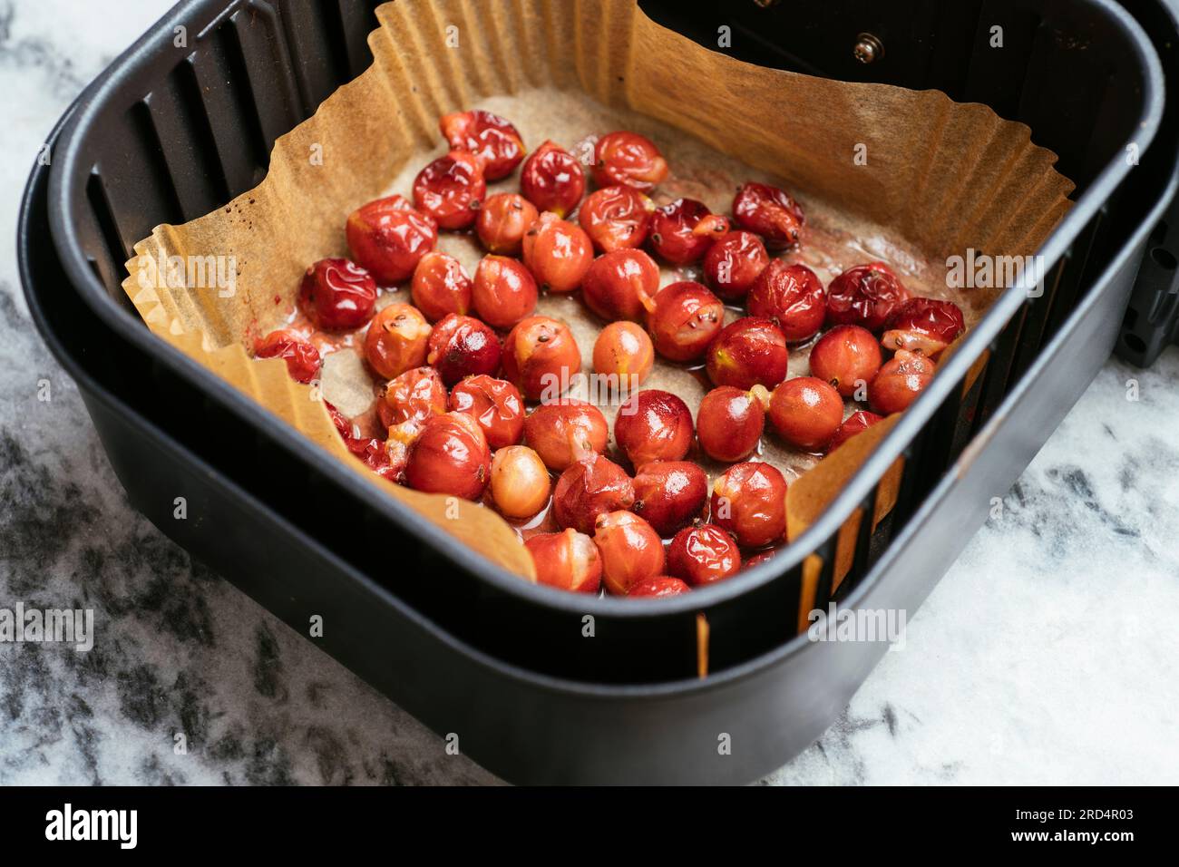 Roasted gooseberries in an Air Fryer basket after being cooked for 5