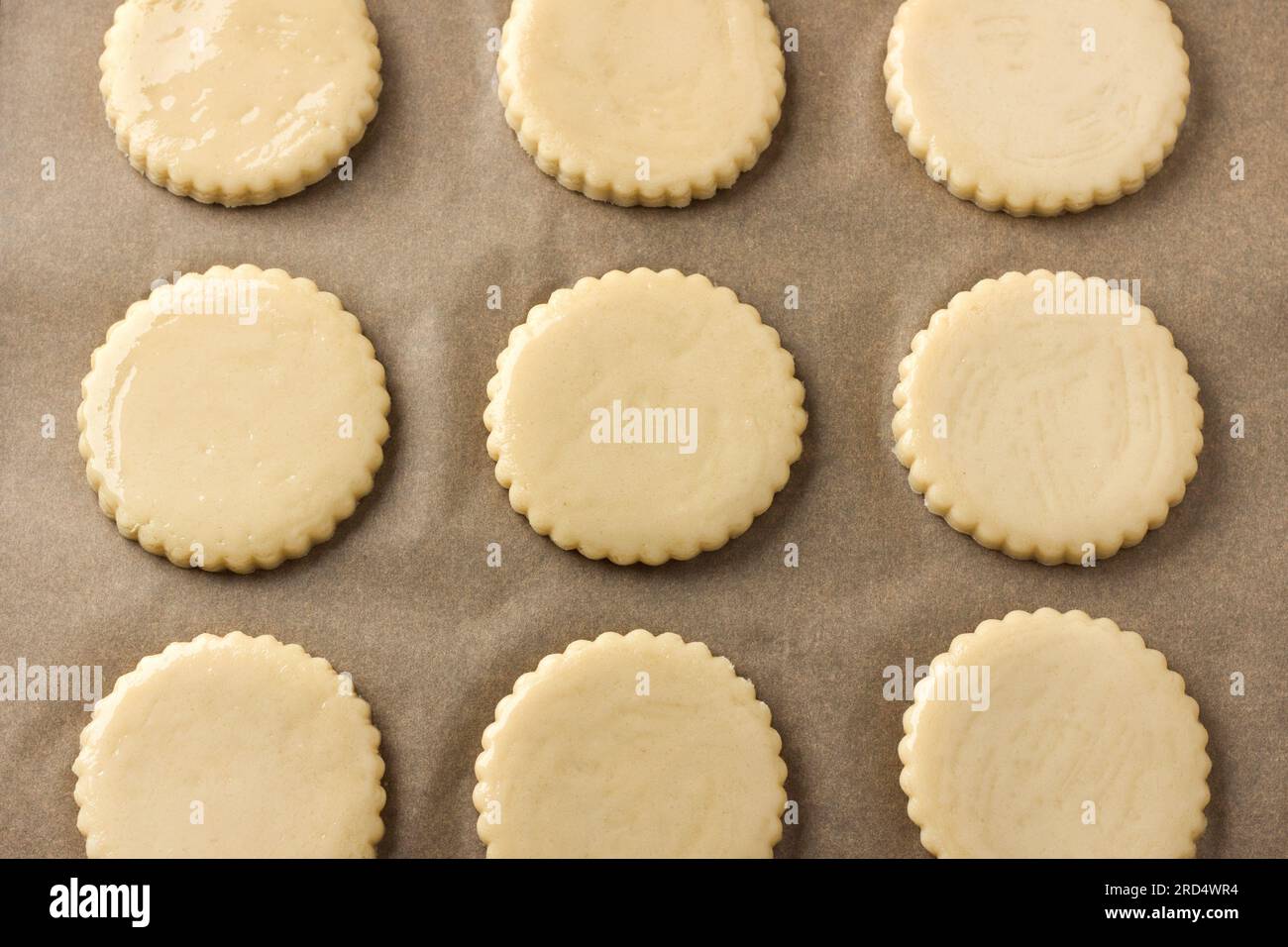 Milk shortbread before baking, greased with egg on parchment, top view. DIY, step by step, step 9. Stock Photo