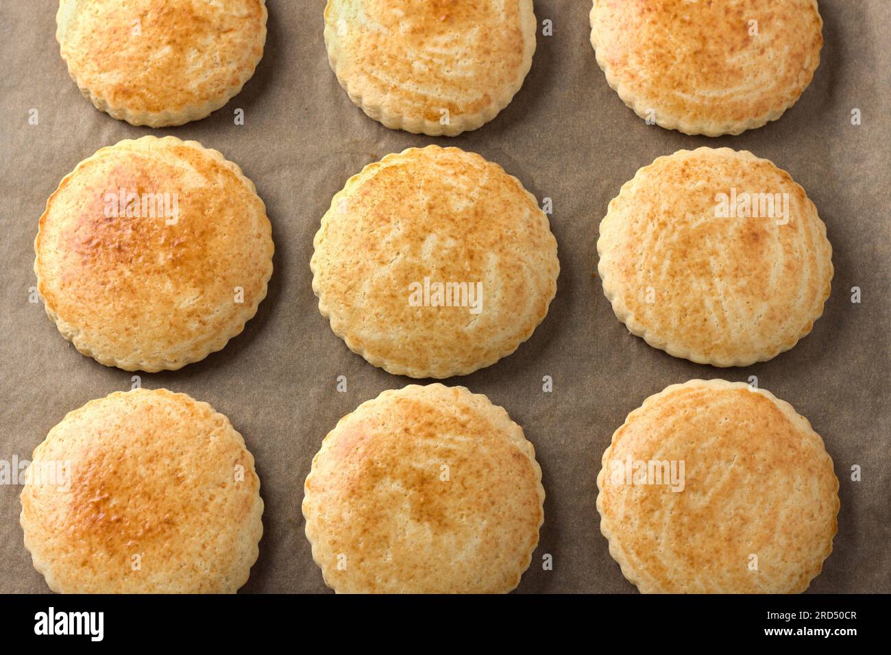 Freshly baked milk shortcakes on parchment, top view. DIY, step by step, step 10. Stock Photo