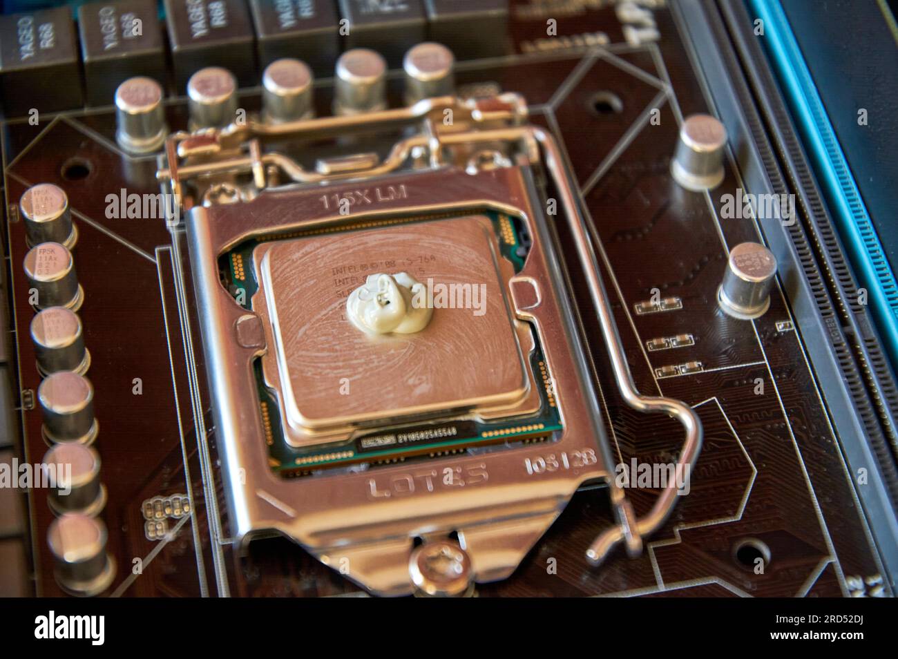 Applying thermal paste to the central processor of the motherboard close up Stock Photo
