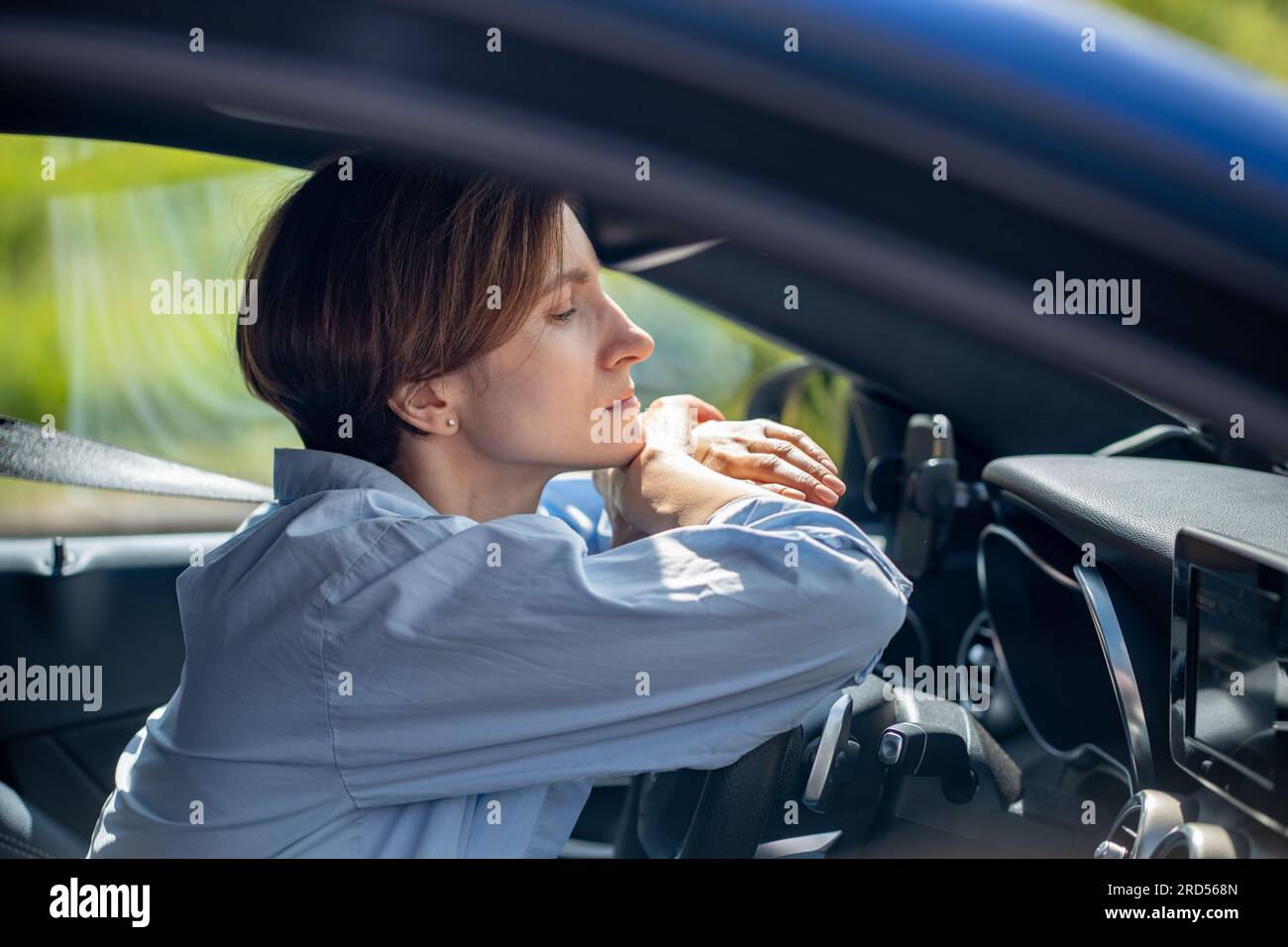 Pensive serious woman standing in traffic jam waiting driving car