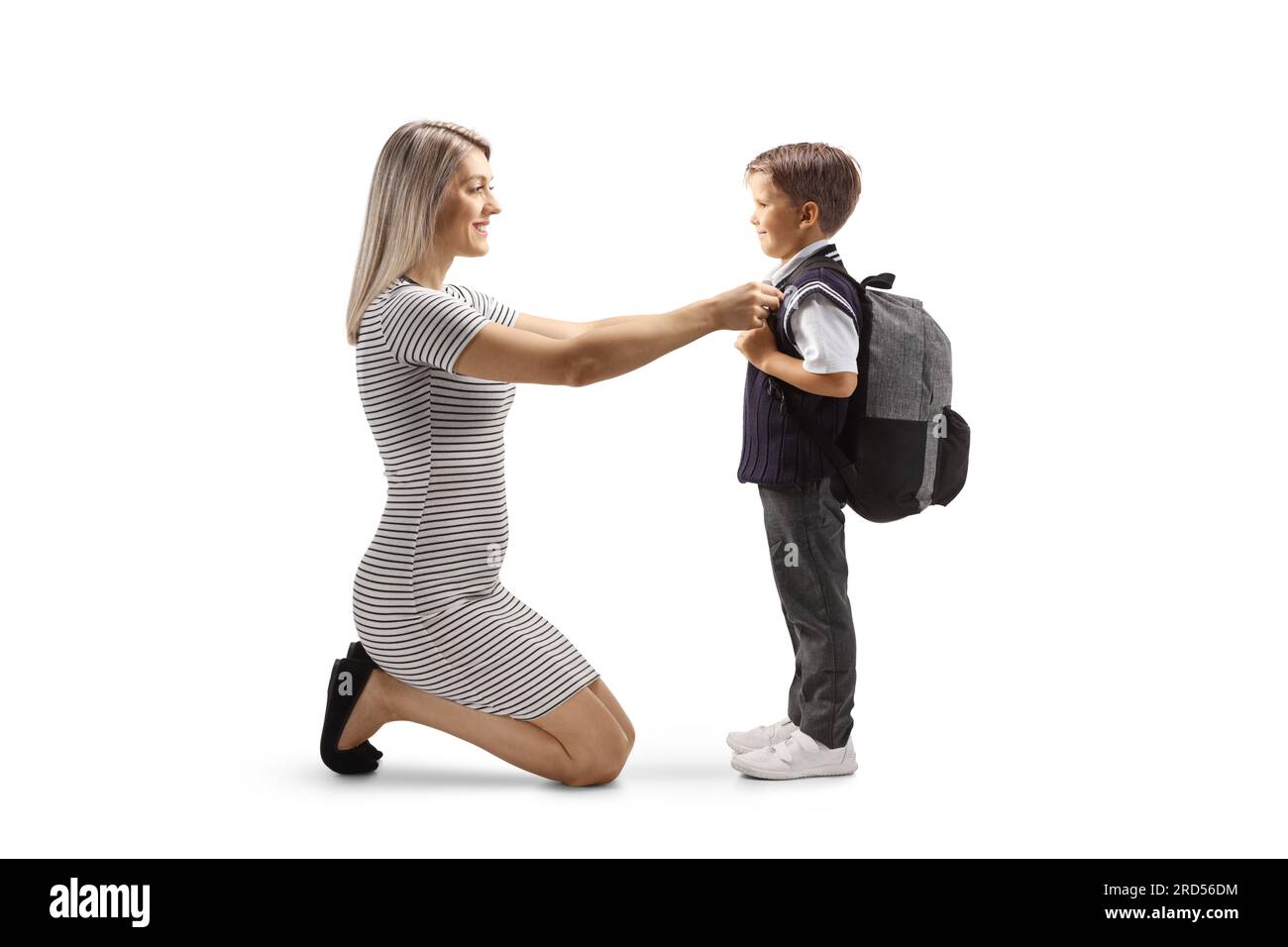 Full length profile shot of a mother helping son getting ready for school isolated on white background Stock Photo