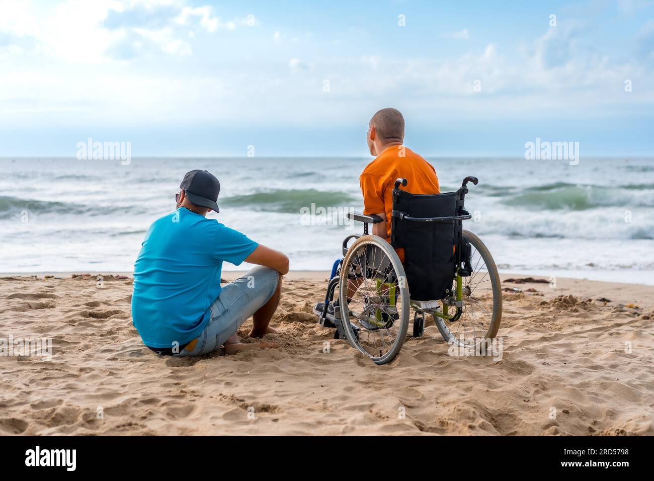 Portrait a disabled person in a wheelchair on the beach with a friends ...