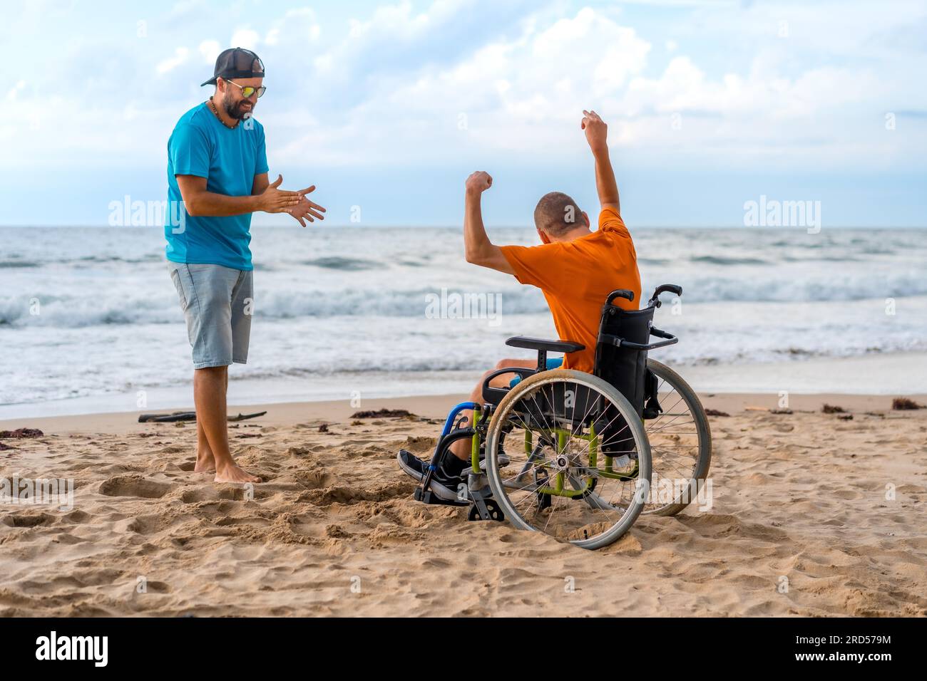 Portrait of a disabled person in a wheelchair on the beach laughing and