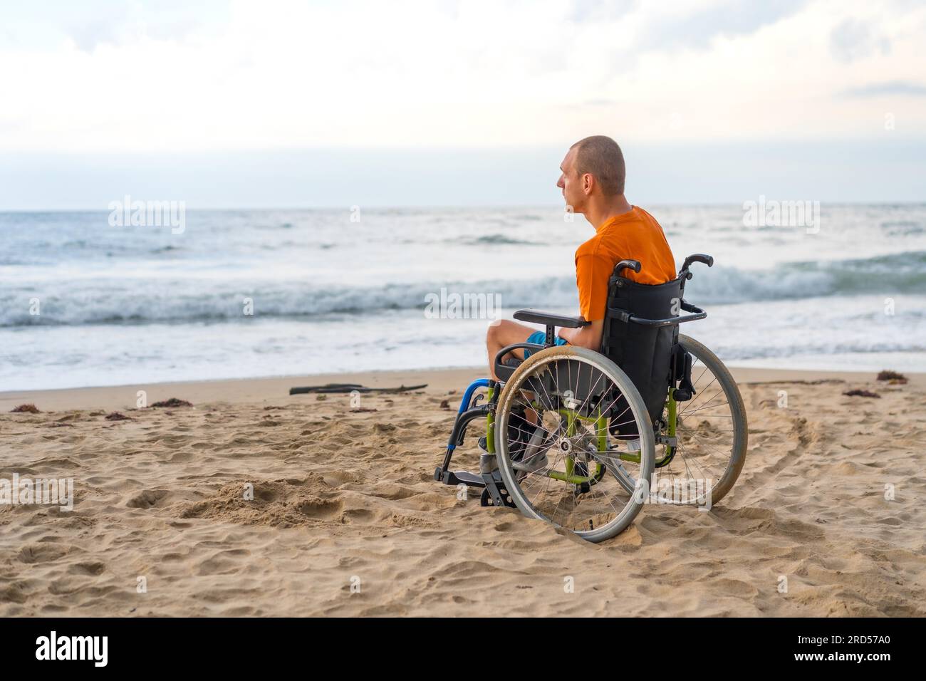 Portrait a disabled person on his back in a wheelchair on the beach