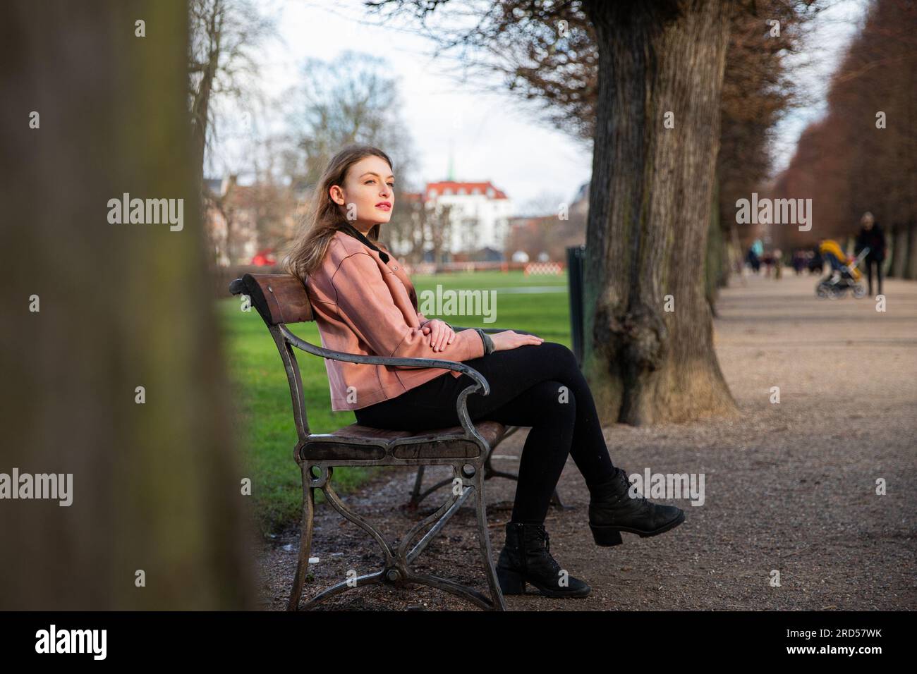 A young woman is sitting on a bench breathing in the fresh winter air