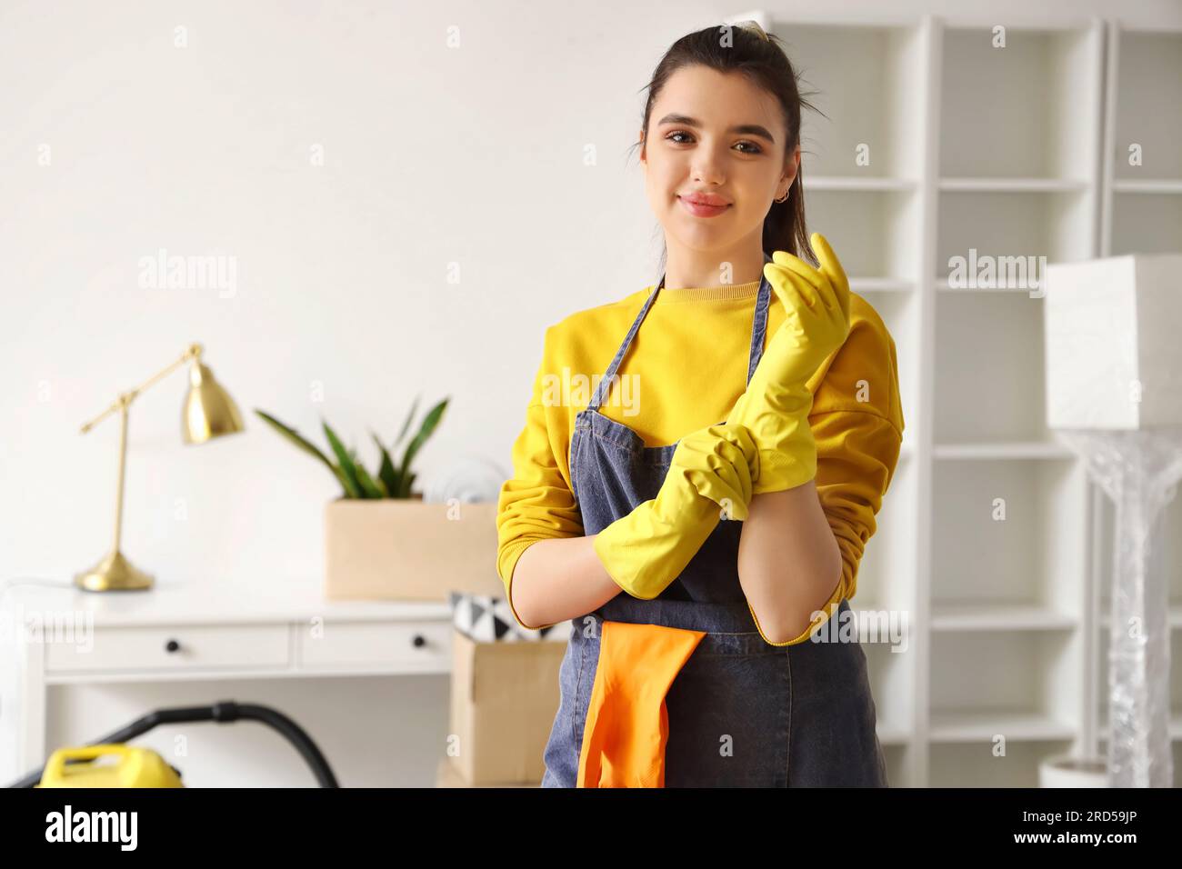 Young woman putting on rubber gloves before cleaning her house Stock ...
