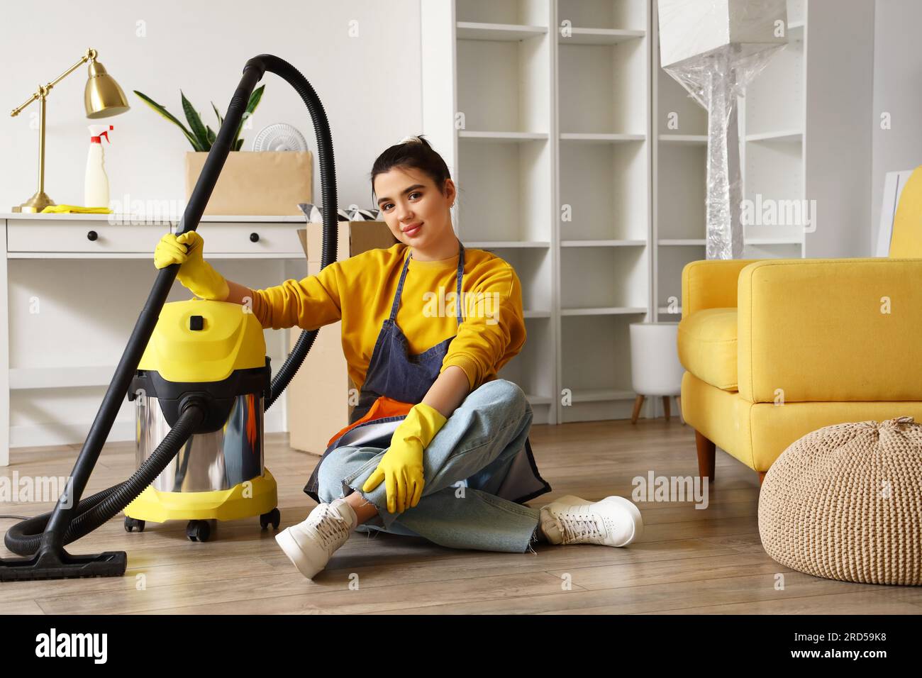 Young woman with vacuum cleaner going to clean her house Stock Photo