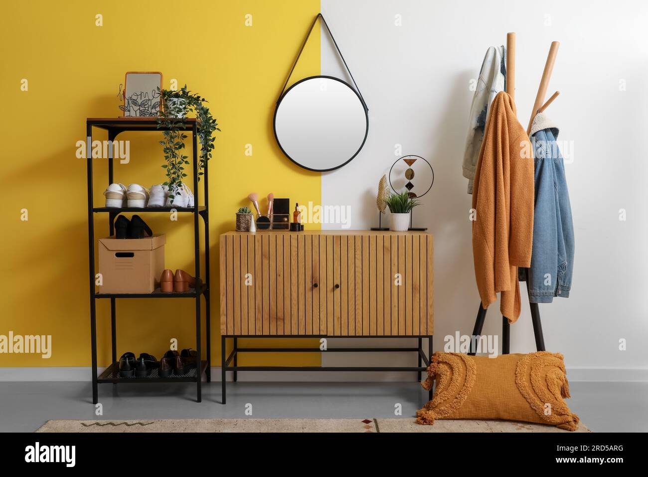 Interior of stylish hallway with mirror, wooden cabinet, shoe stand and rack Stock Photo