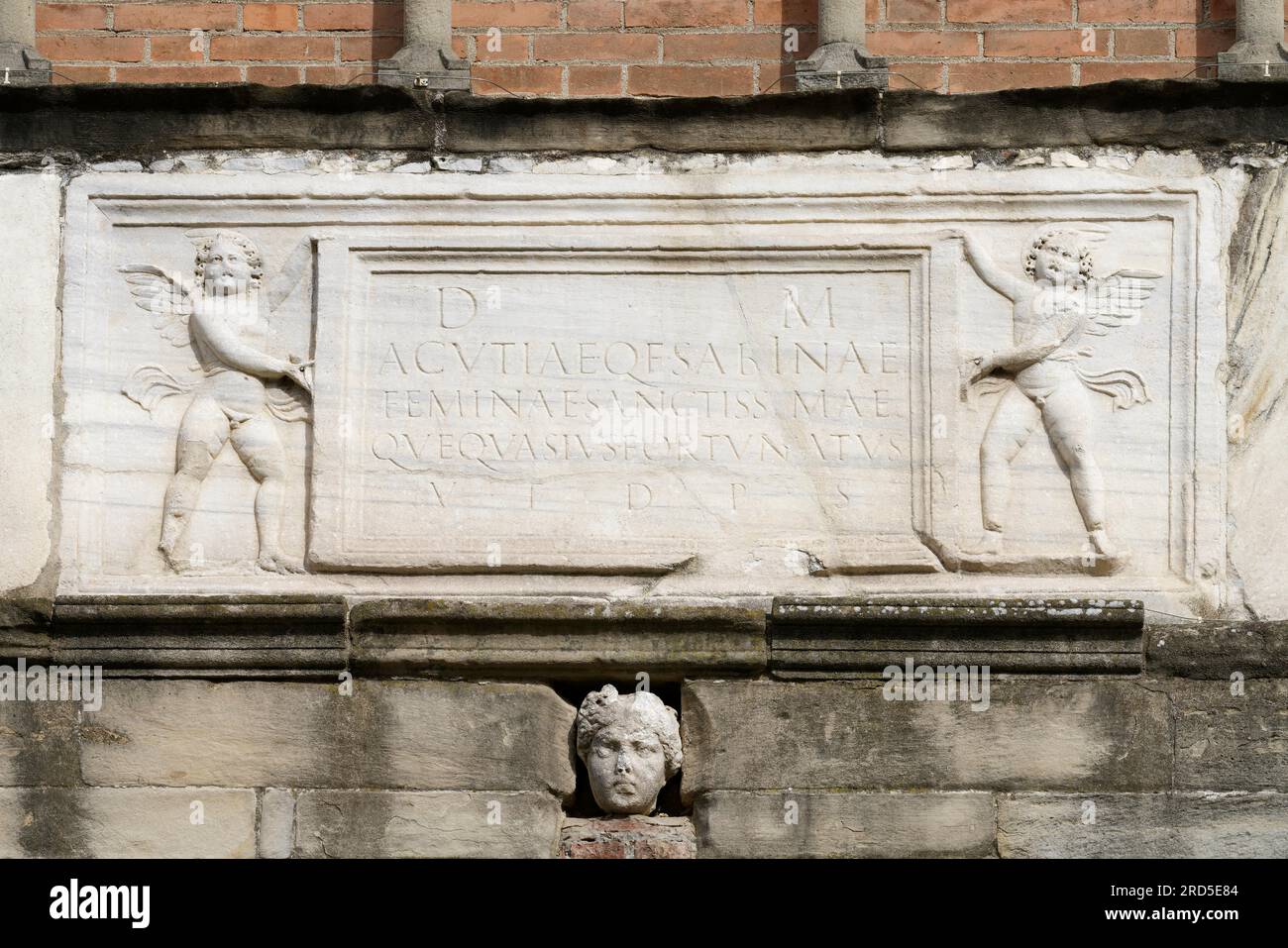 Roman spolia with two angels and Latin inscription, facade of the church of San Pietro, Cherasco, province of Cuneo, Langhe, Piedmont, Italy Stock Photo
