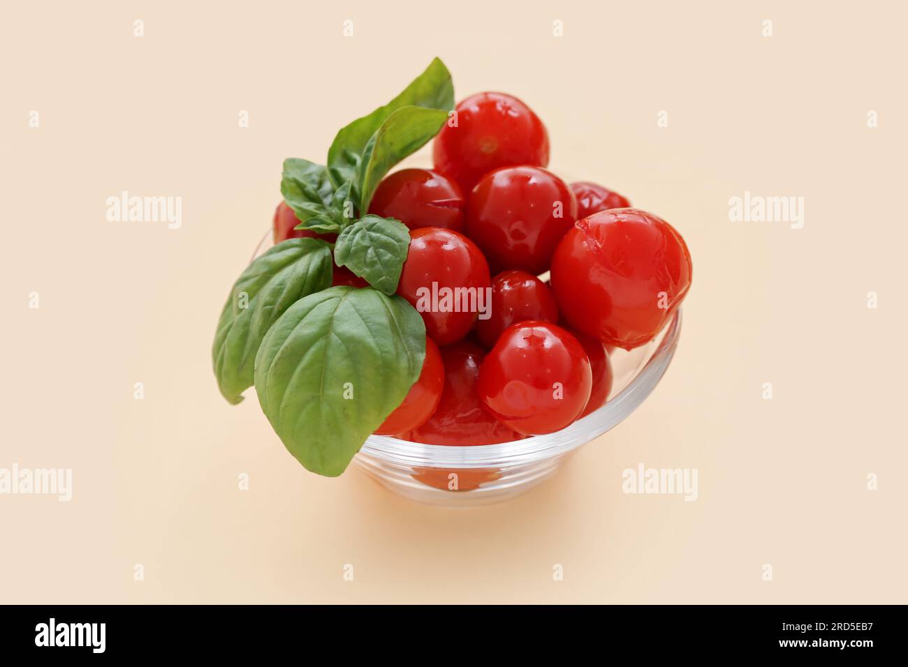 Glass bowl with canned tomatoes and basil on yellow background Stock ...
