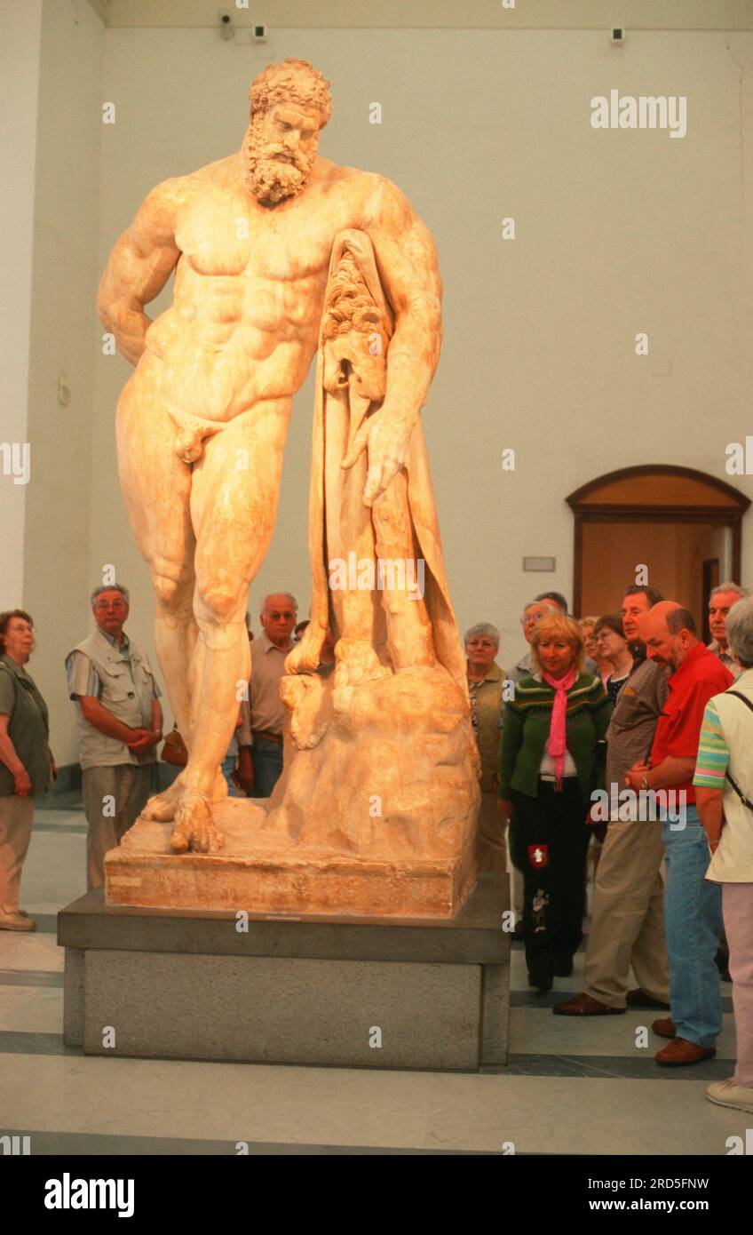 Visitor at sculpture 'Hercules Farnese', National Archaeological Museum
