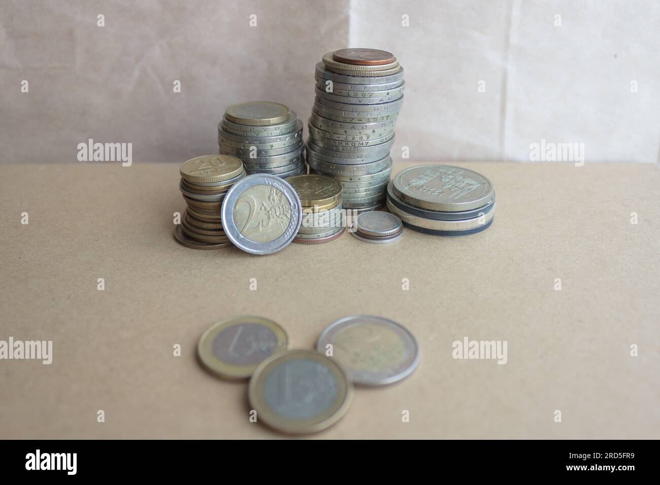 A collection of coins from different countries and times on a craft background. Stock Photo