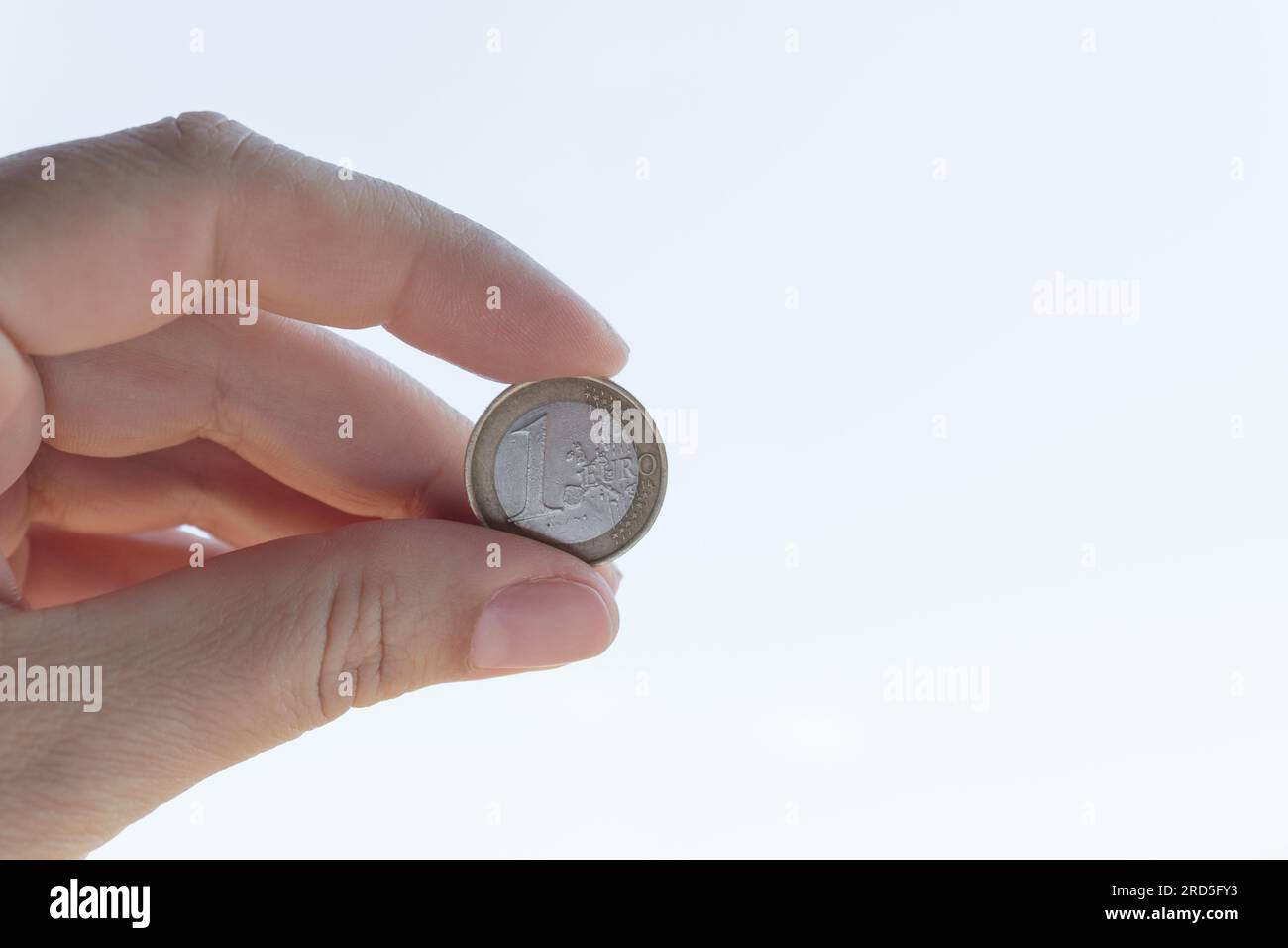 1 euro coin in hand close-up. Cash coin in hand on a white background. Stock Photo