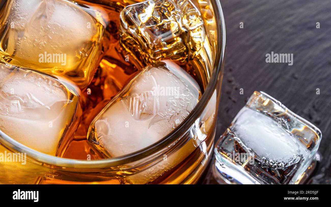 https://c8.alamy.com/comp/2RD5JJF/golden-whiskey-in-glass-with-ice-cubes-on-table-top-view-space-for-text-2RD5JJF.jpg