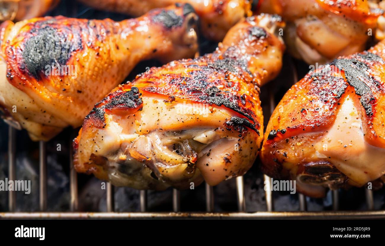 Chicken grilled charcoal on a black iron grill. The chicken is light