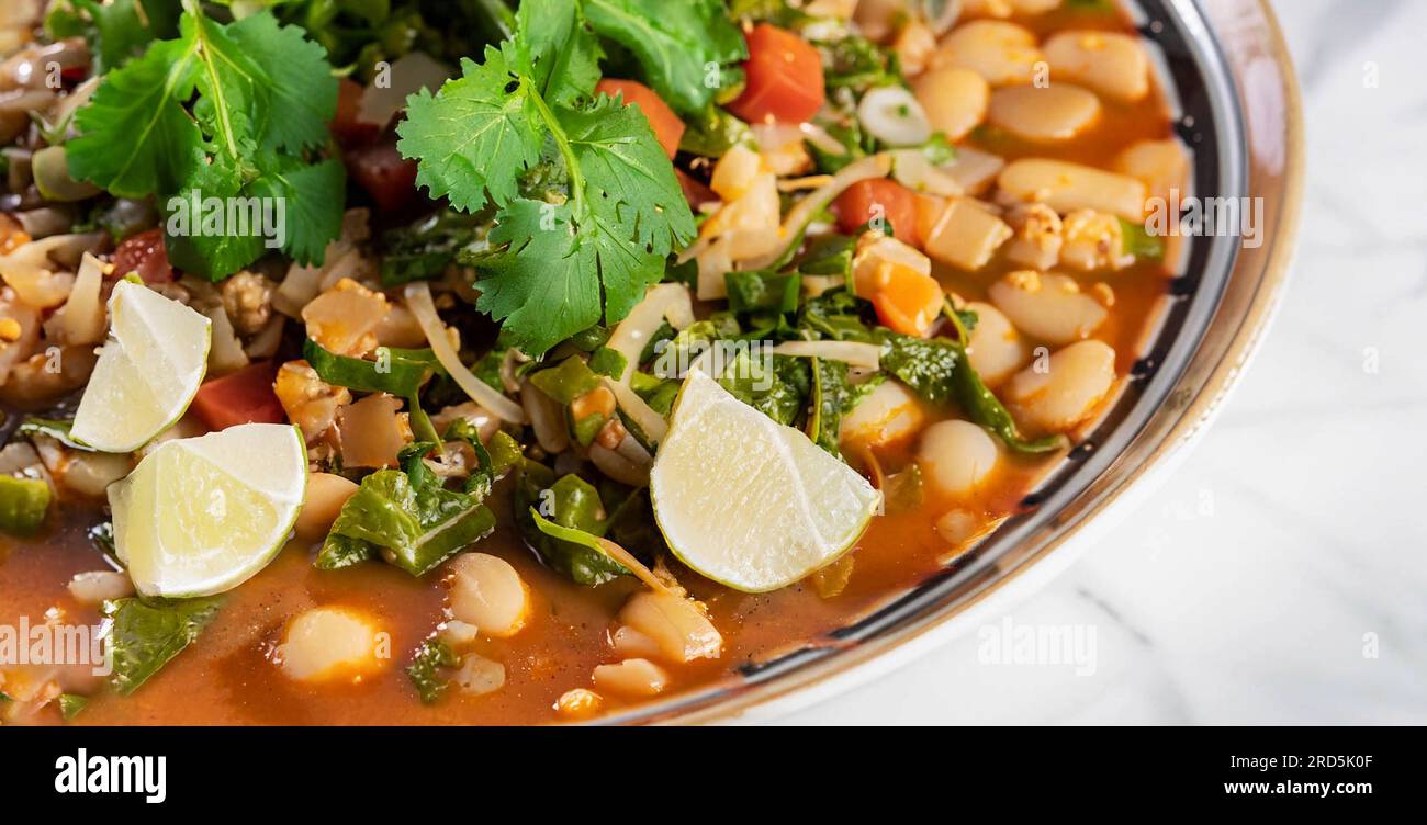 Mexican cuisine, chicken pozole served with radishes, lemons and toast