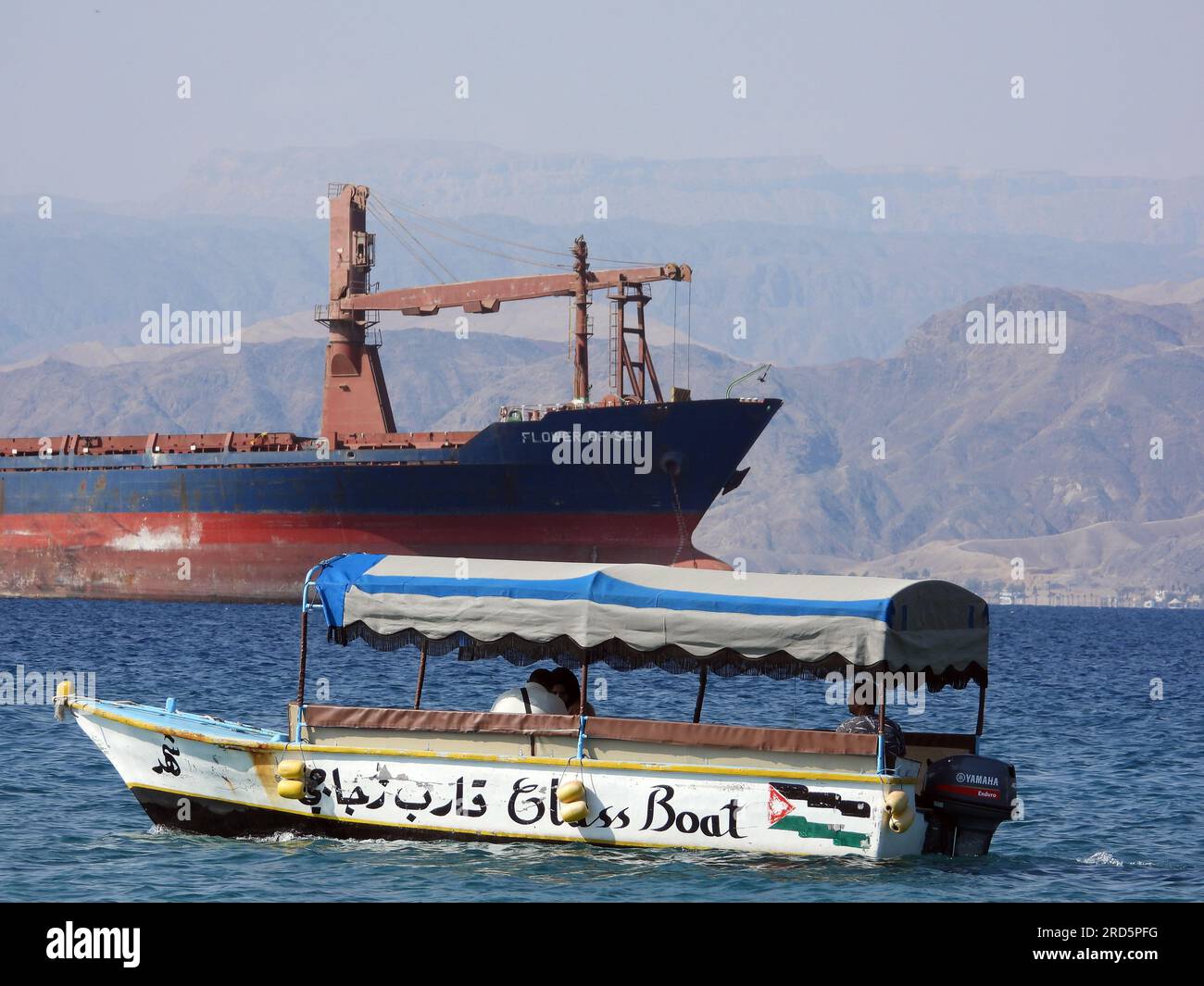 Aqaba, Jordan Jordanian tourist glass boat at the weekend and a cargo
