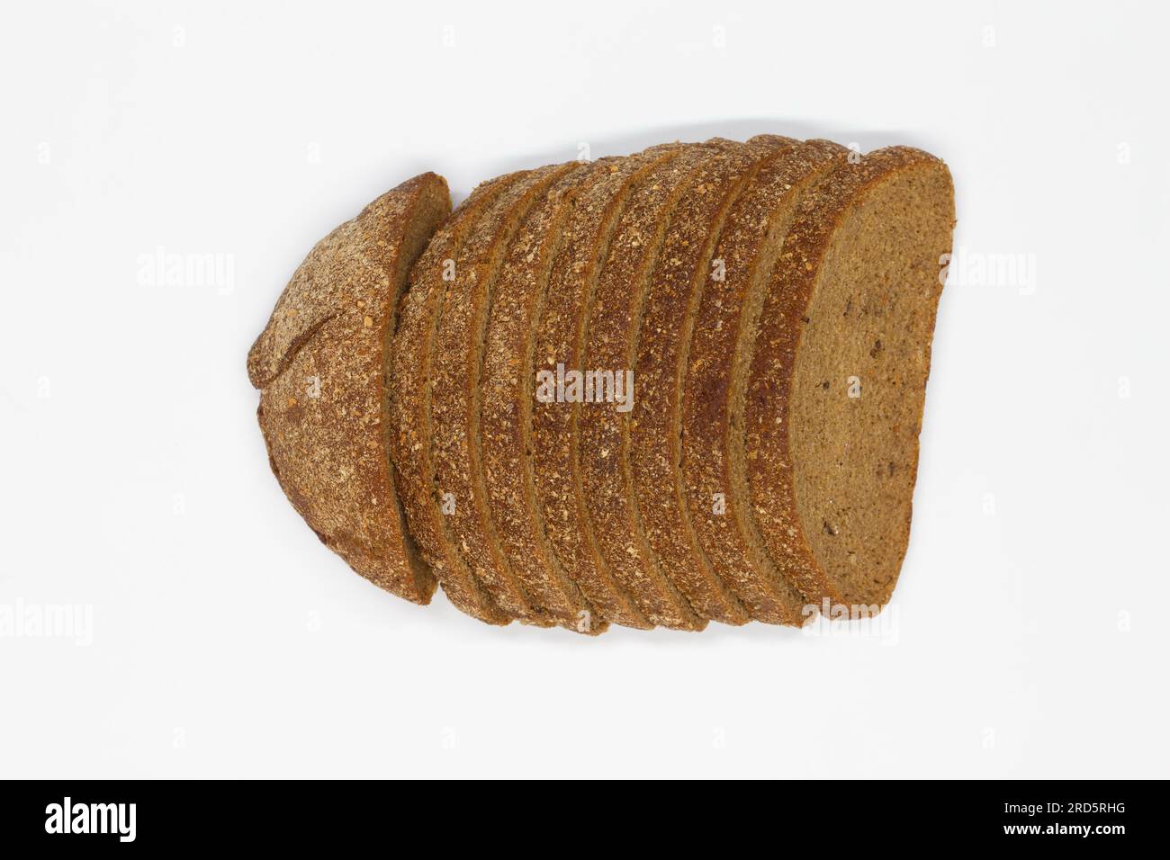 Sliced black bread. Dark rye bread with cumin cut into even pieces on a white background. Wheat black bread on the table. Isolated. Bran from grain. Stock Photo