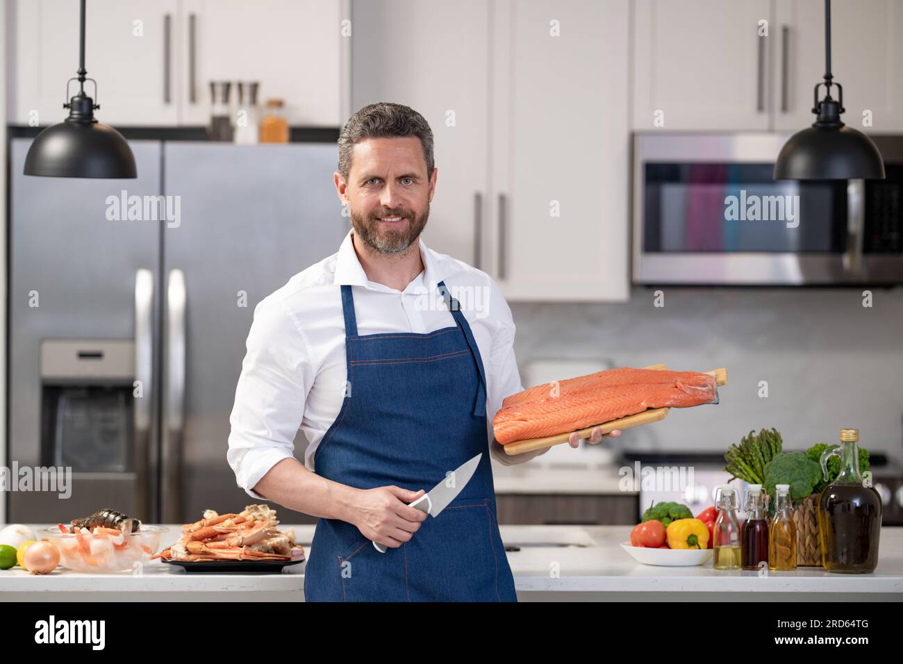 positive man cook delicacy salmon fish. man cook delicacy salmon in the ...