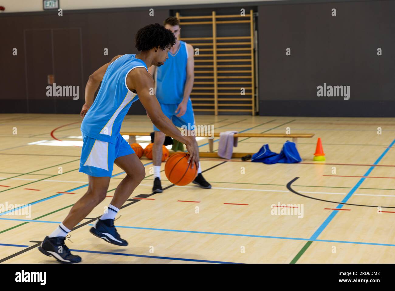 Diverse male basketball players wearing blue sports clothes and playing  basketball at gym Stock Photo - Alamy 