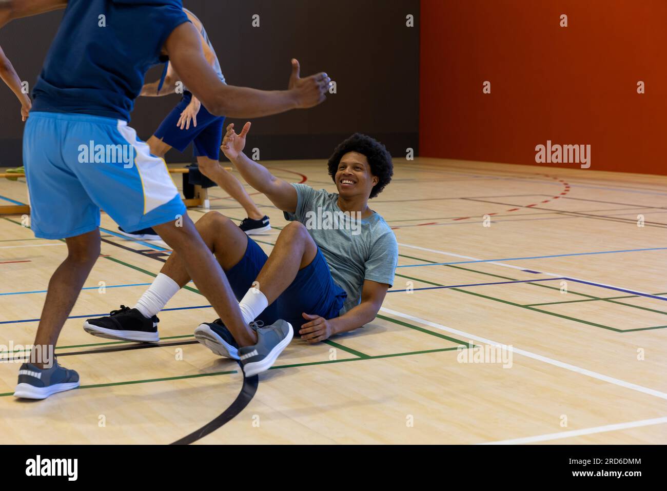 Diverse male basketball players helping to get up at gym, copy space Stock Photo Alamy