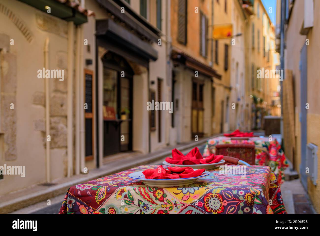 Outdoor tables waiting for customers at a street cafe in the old town or Vieil Antibes, South of France Stock Photo