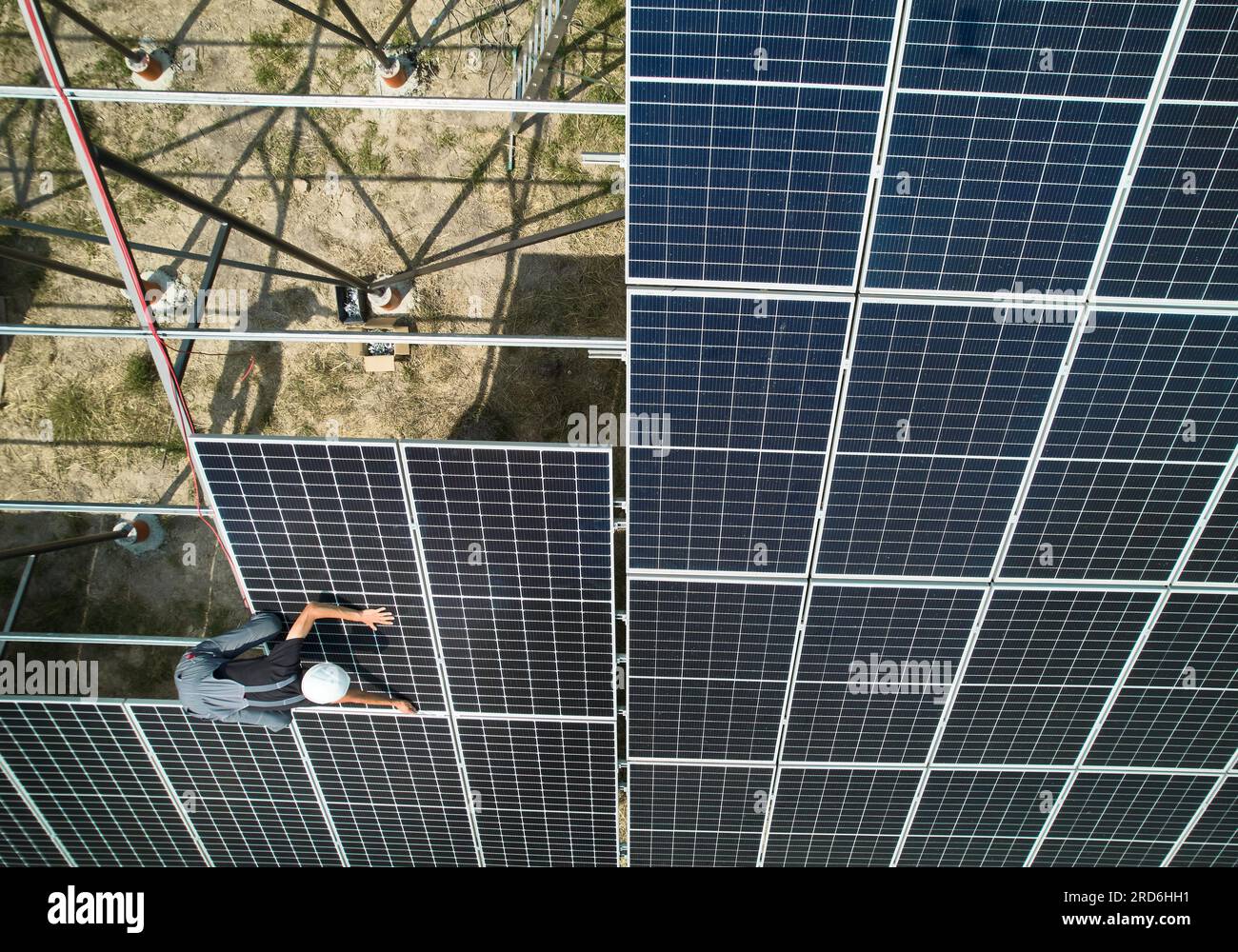 Aerial view of man technician installing photovoltaic solar panels to ...