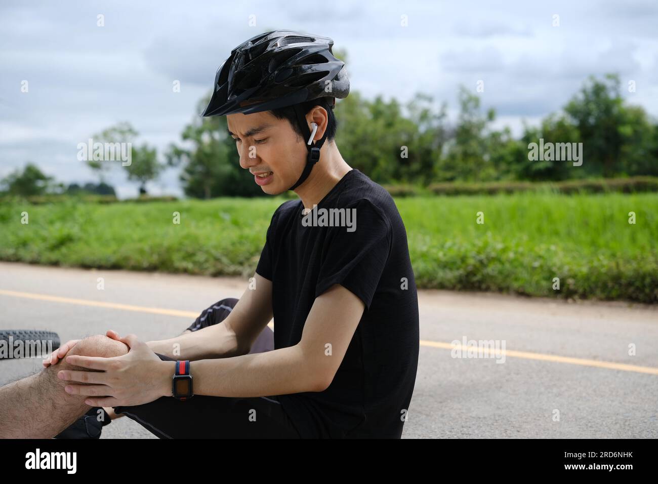 Photo of injured man experiencing severe pain by knee after bicycle