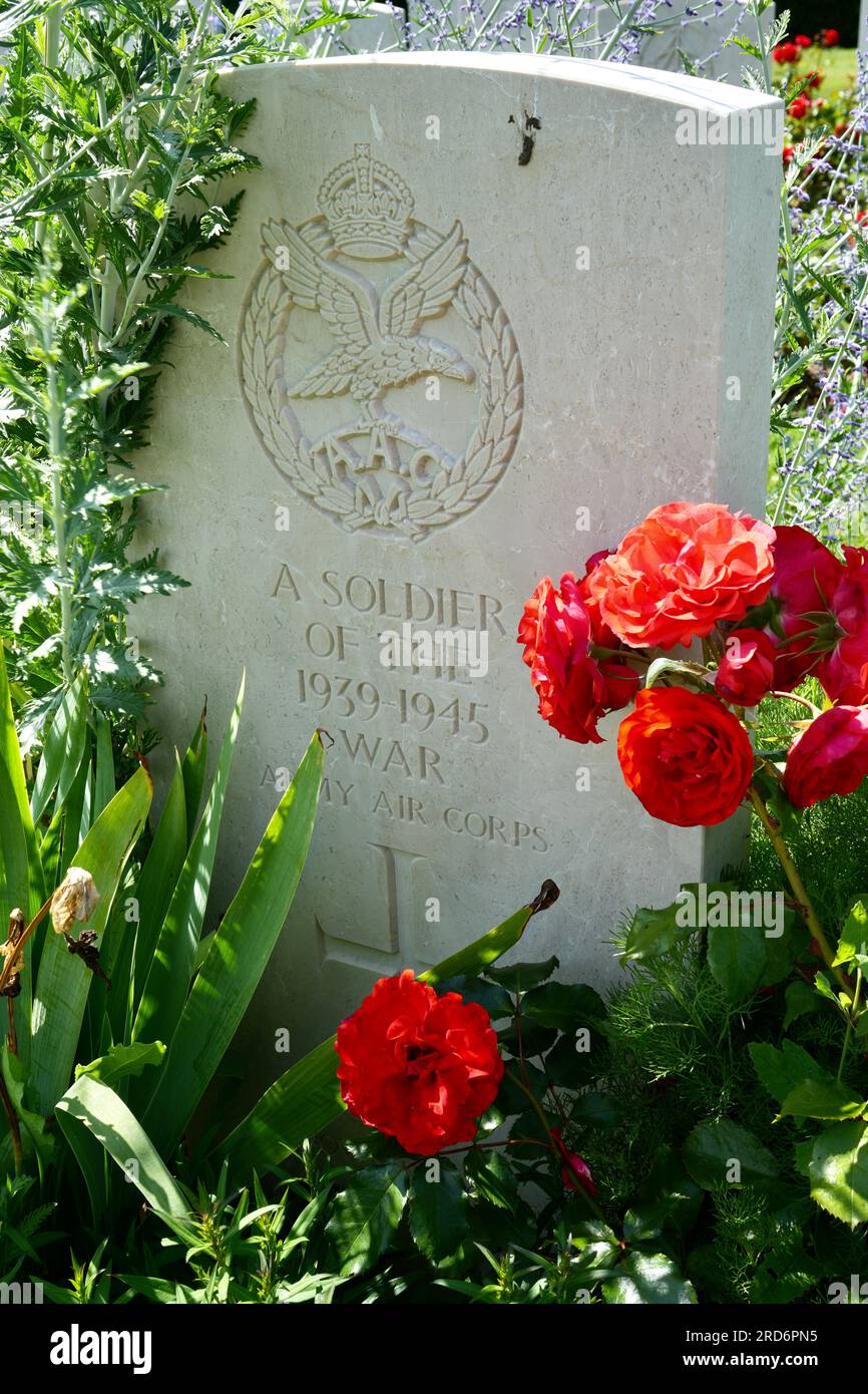 Grave Marker with red flowers for an Unknown Army Air Corps Soldier at The Bayeux war cemetery. Bayeux, France Stock Photo