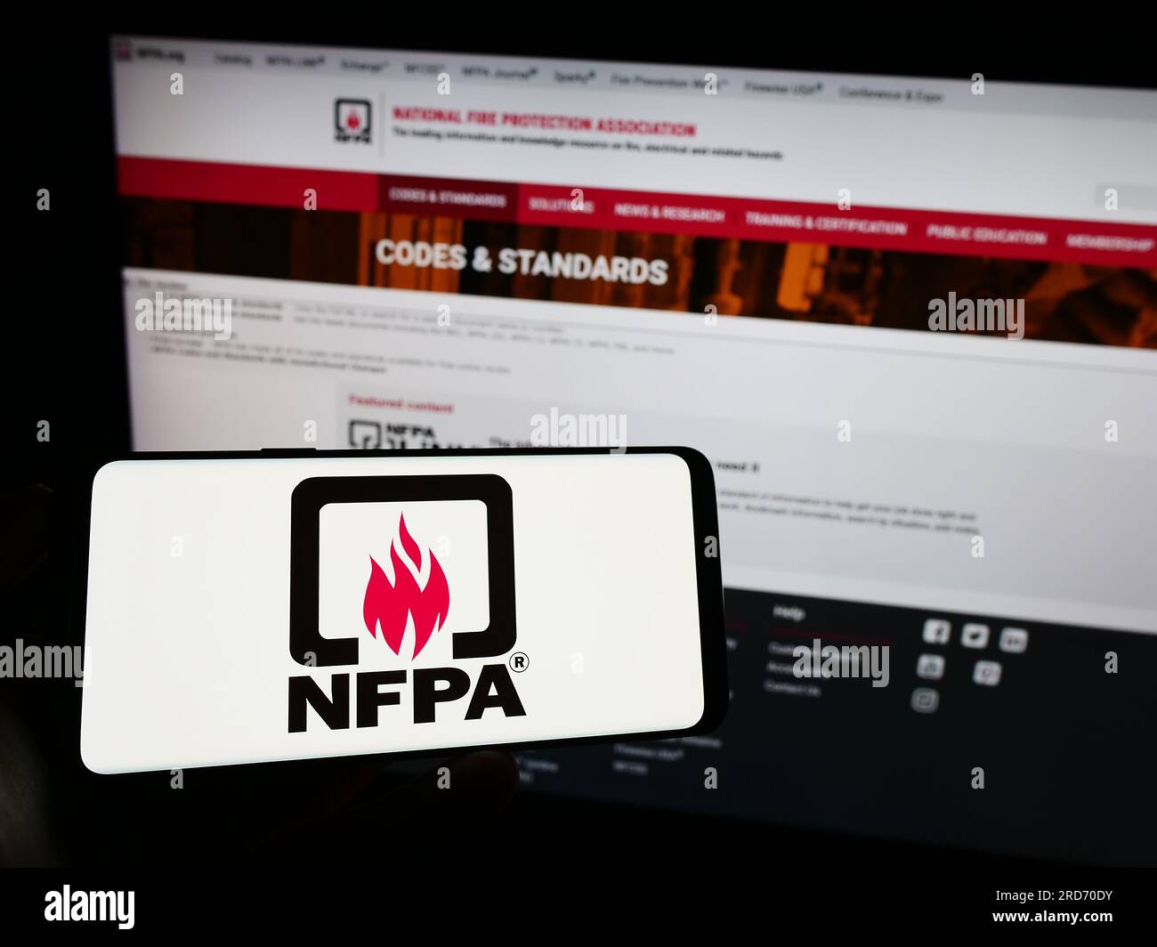 Person holding cellphone with logo of National Fire Protection
