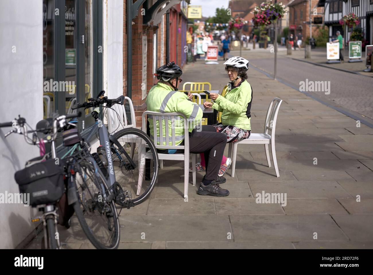 Senior cyclists taking a break at a street cafe. Stratford upon Avon, England, UK Stock Photo
