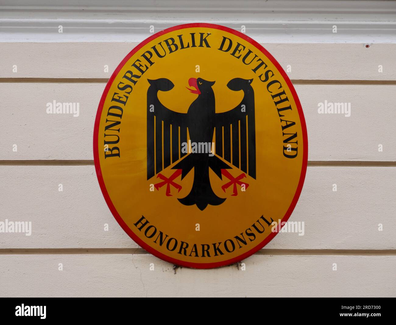 Close up of the yellow sign with the eagle coat of the Federal Republic of Germany on the Honorary Consulate building in Bolzano, Italy. Stock Photo