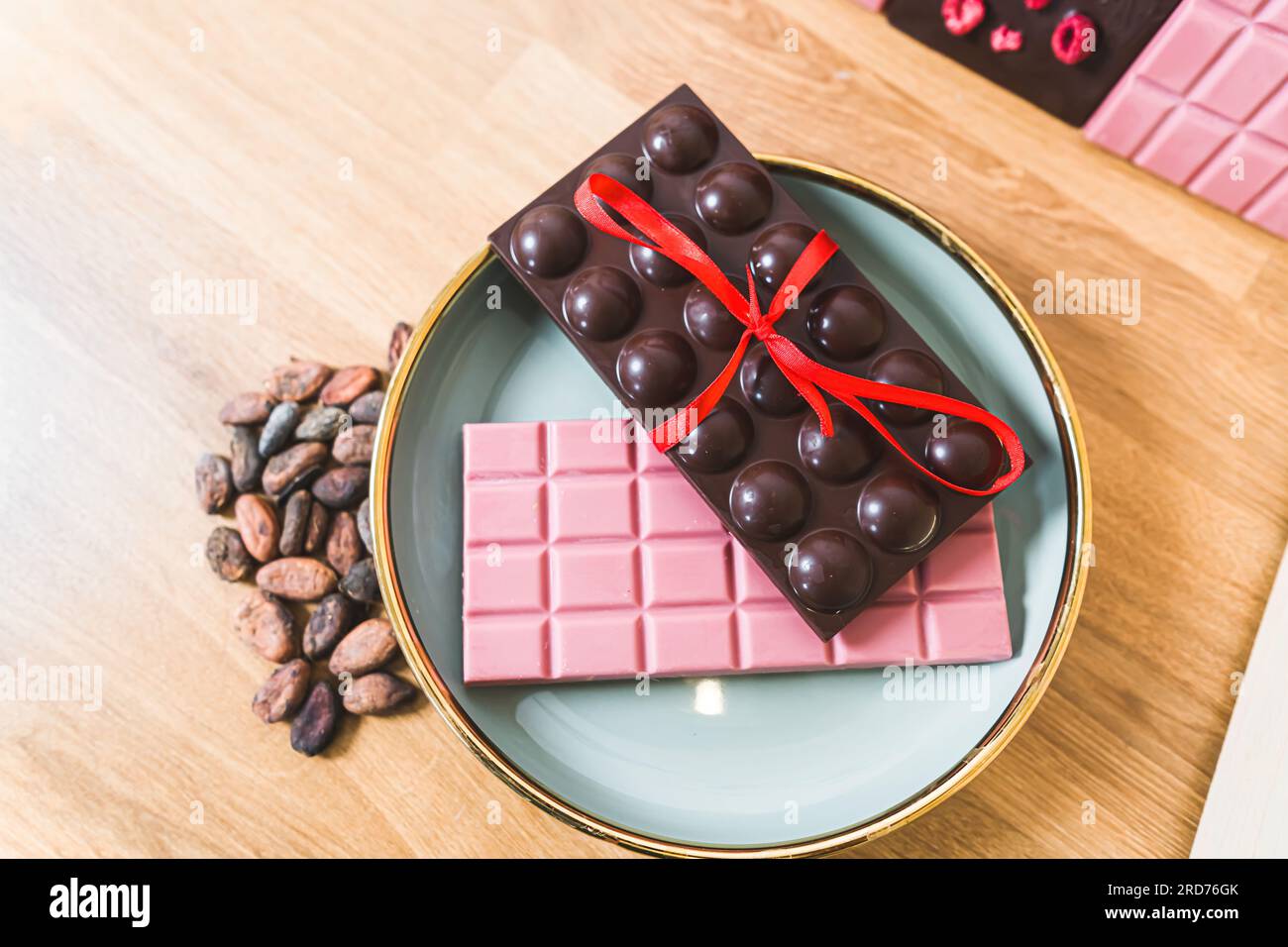 Top indoors closeup shot of bars of chocolae exhibited on blue plate. Gift idea concept. Delicious ruby and dark chocolate. . High quality photo Stock Photo