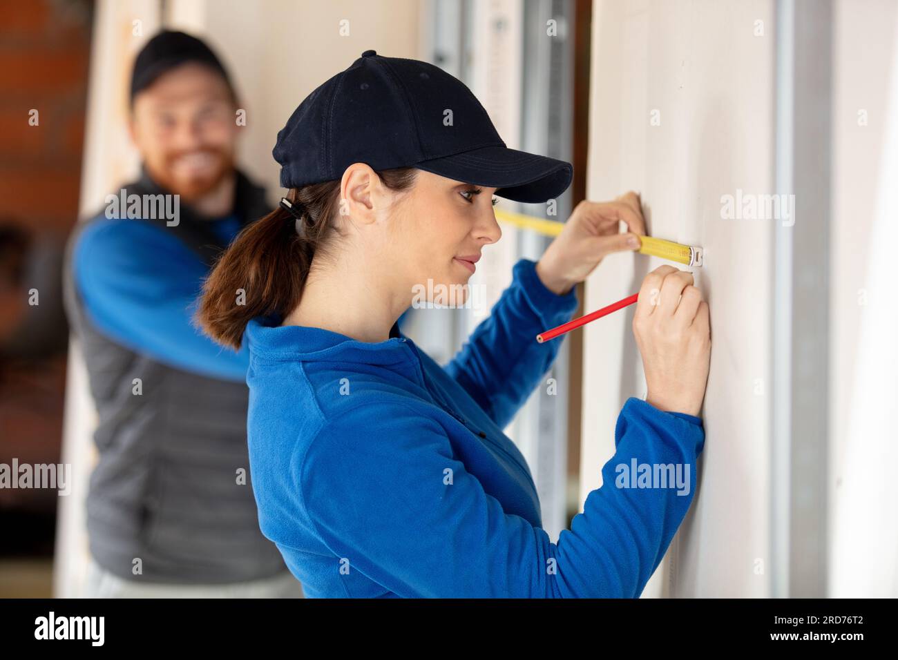woman construction worker using measure tape and pencil Stock Photo