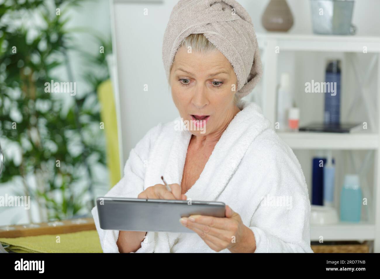 surprised senior woman looking at tablet Stock Photo