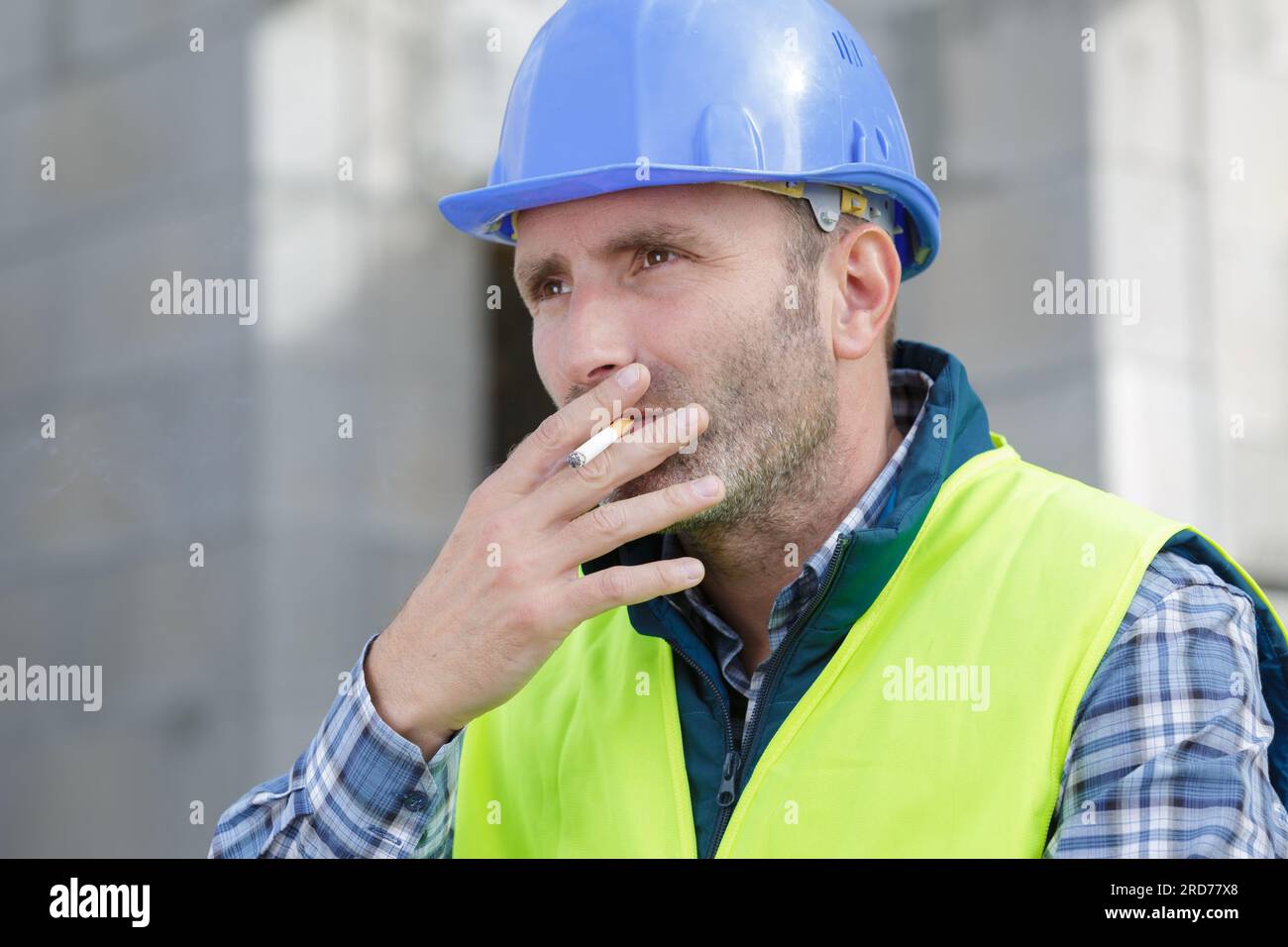 male builder smoking a cigarette Stock Photo