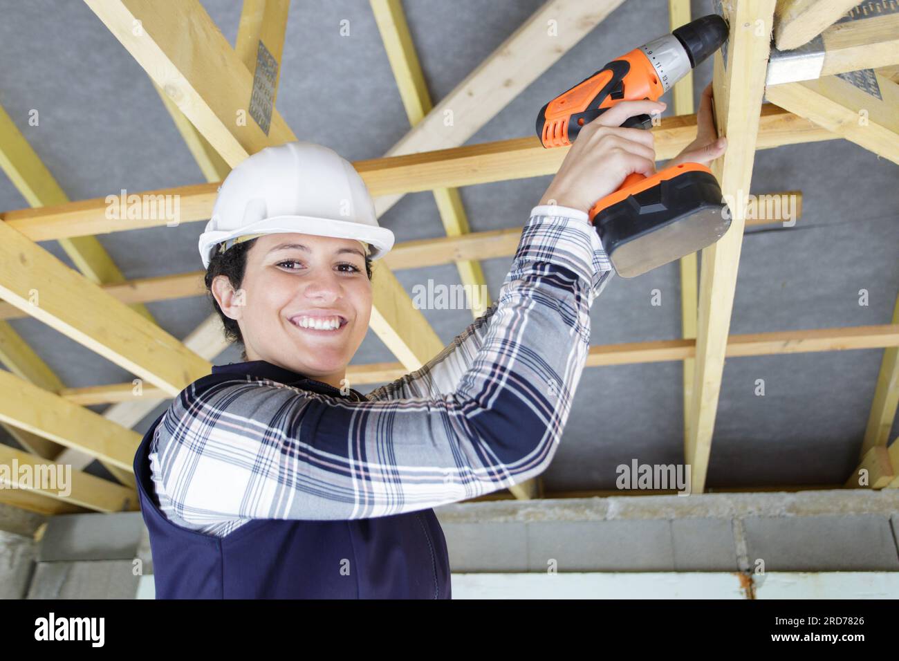female carpenter using a drill on a wood structure Stock Photo