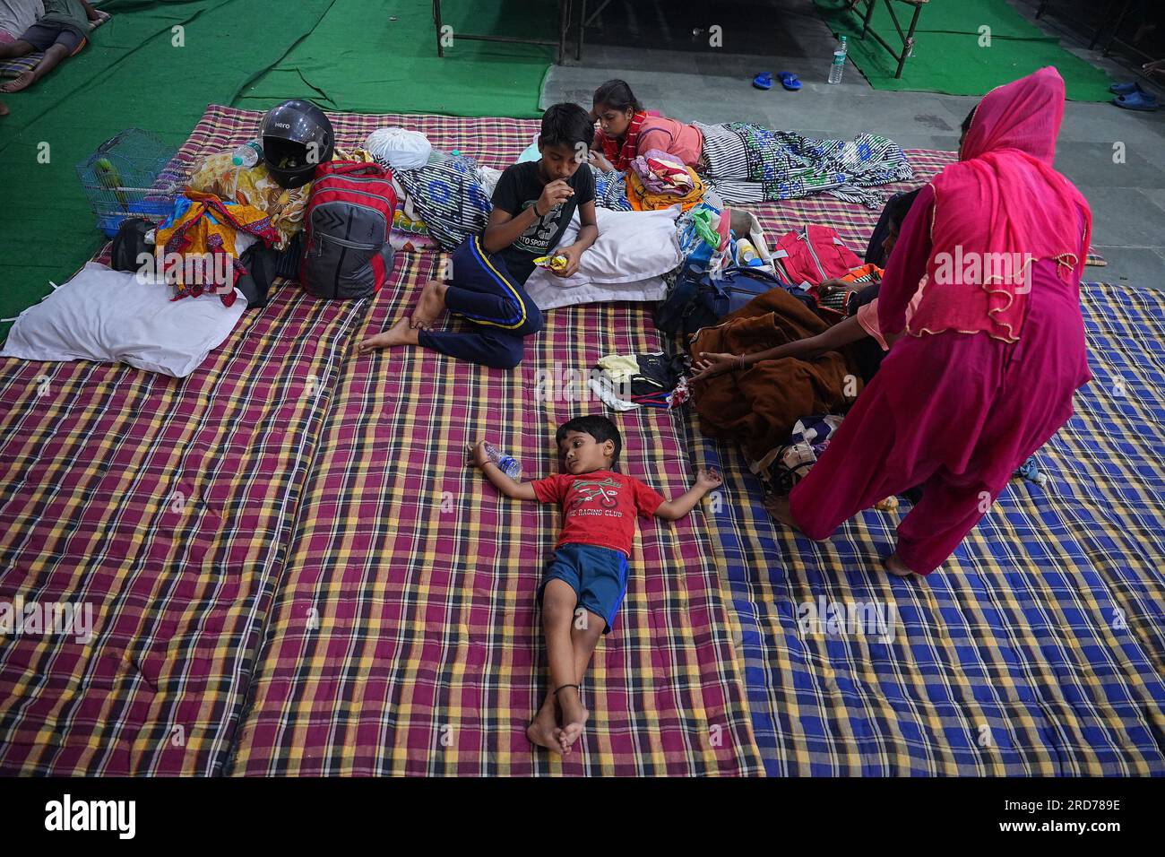 New Delhi, India. 18th July, 2023. A child lying on a cotton mat in their floof relief camp. People from low lying area around the Yamuna River after being relocated to camps after the Yamuna River overflowed due to heavy monsoon rainfall. (Photo by Shivam Khanna/Pacific Press) Credit: Pacific Press Media Production Corp./Alamy Live News Stock Photo