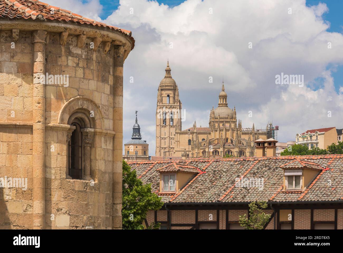 Old Spanish city skyline, view of the Baroque Cathedral in Segovia showing the romanesque apse of the Iglesia de San Millan in the foreground, Spain. Stock Photo