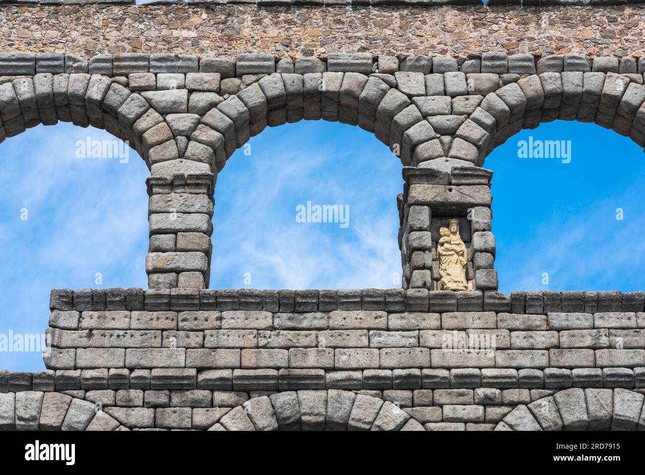 Spain Roman aqueduct, detail of the upper tier stonework of the Roman aqueduct in Segovia showing a statue of the Virgin Mary sited in a niche, Spain Stock Photo