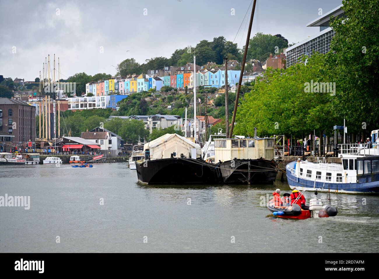 Bristol floating harbour in rain with boats looking up to colourful