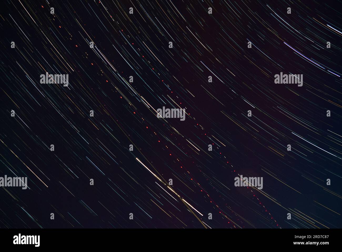 Traces of starlight and aircraft lights in the night sky Stock Photo