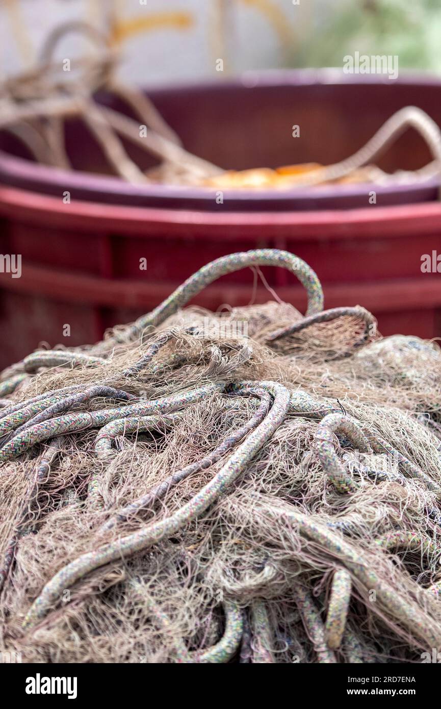 Tangled Fish Rope tangled fishing nets piled on the harbour wall with a bucket of ropes ...