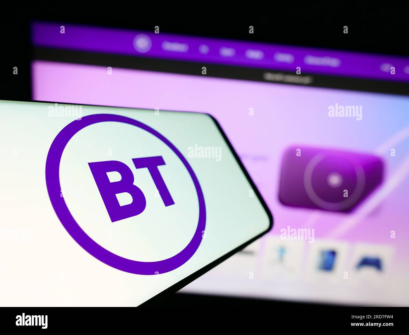 Mobile phone with logo of British company BT Group plc on screen in front of